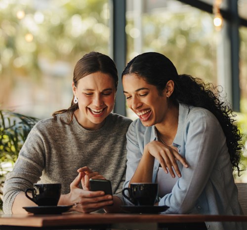 girls laughing over coffee
